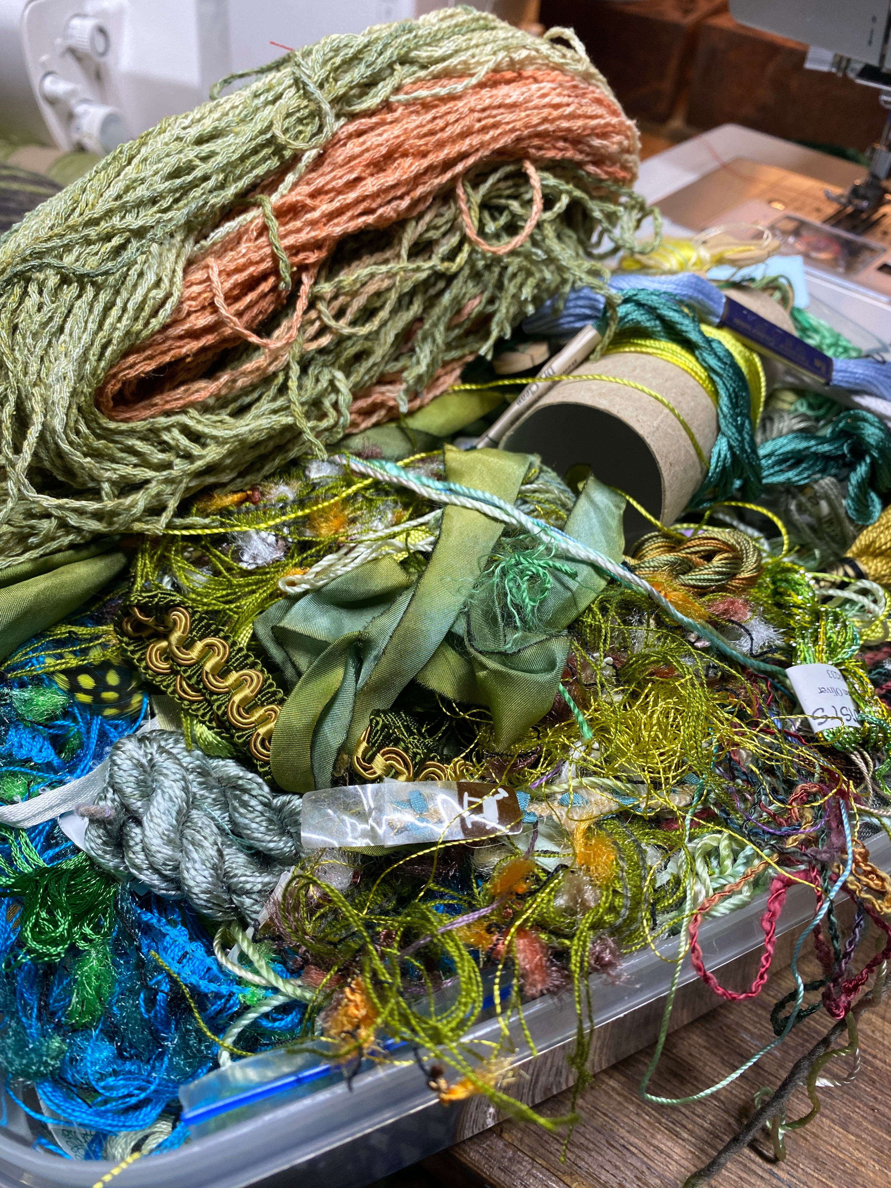 Colorful skeins of yarn in various textures and colors on a wooden surface.