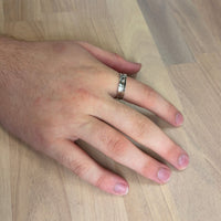 Hand with a ring on a wooden surface